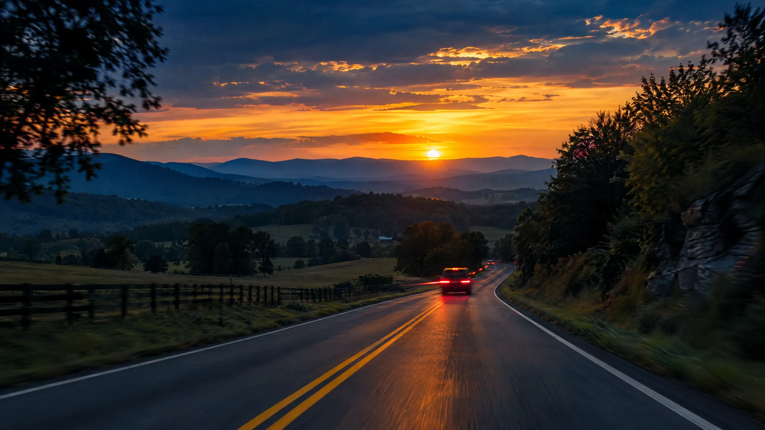 Two-lane rural Virginia highway at sunset with motion-blurred tail lights